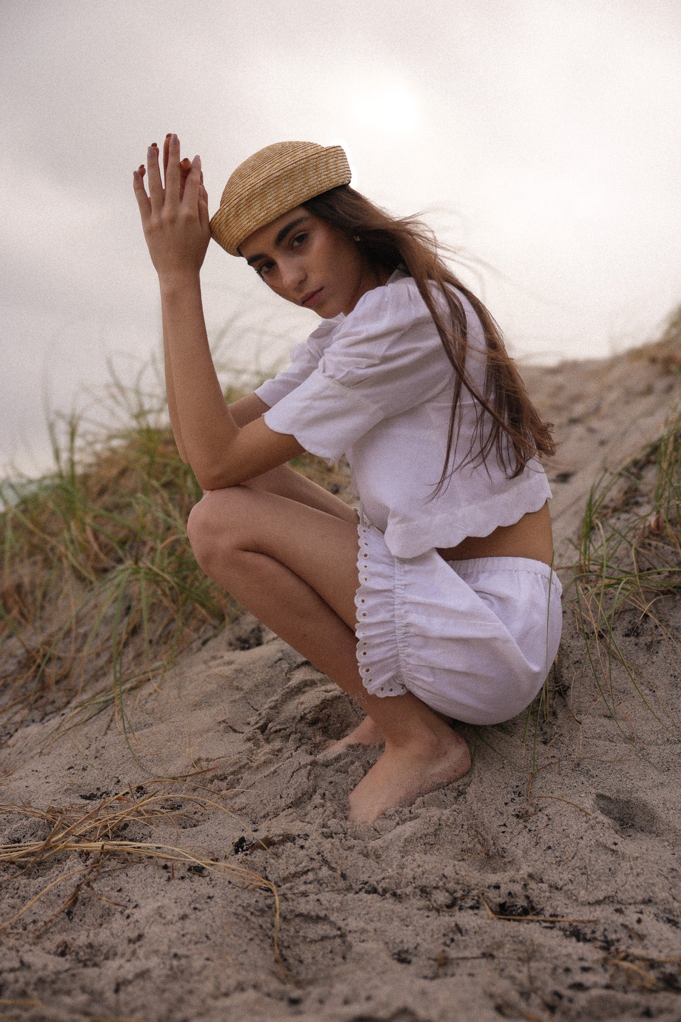Model wearing a navy Sister New York sweatshirt with white eyelet shorts, standing beside a scooter.