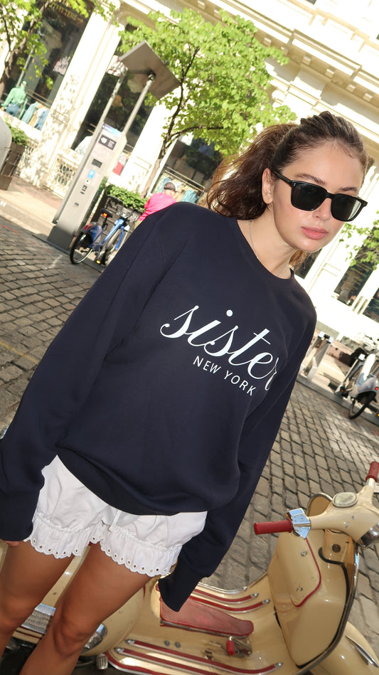 Made in NYC from 100% cotton, this navy crewneck sweatshirt blends comfort and style with its signature sister script and bold “NEW YORK” print. A relaxed fit and soft fleece make it perfect year-round.
