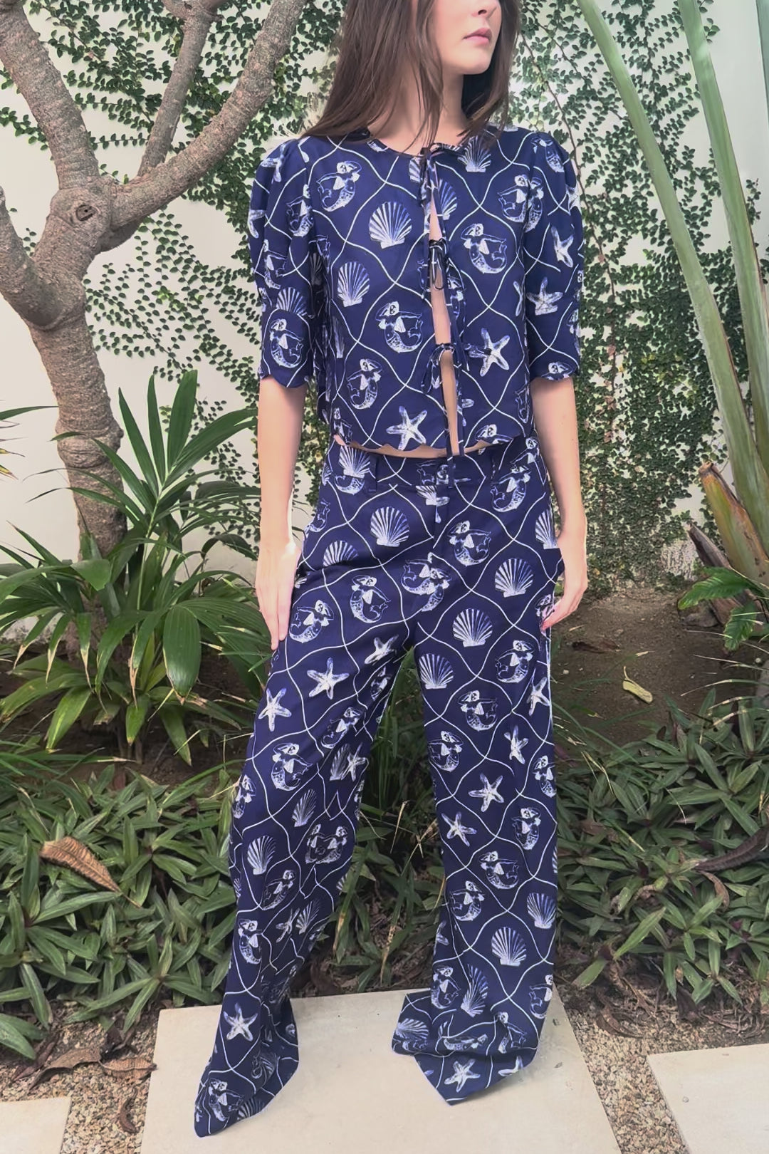 Woman modeling a blue printed linen set with matching top and pants in an outdoor setting