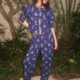 Model wearing a blue printed pajama set with matching top and pants, standing outdoors
